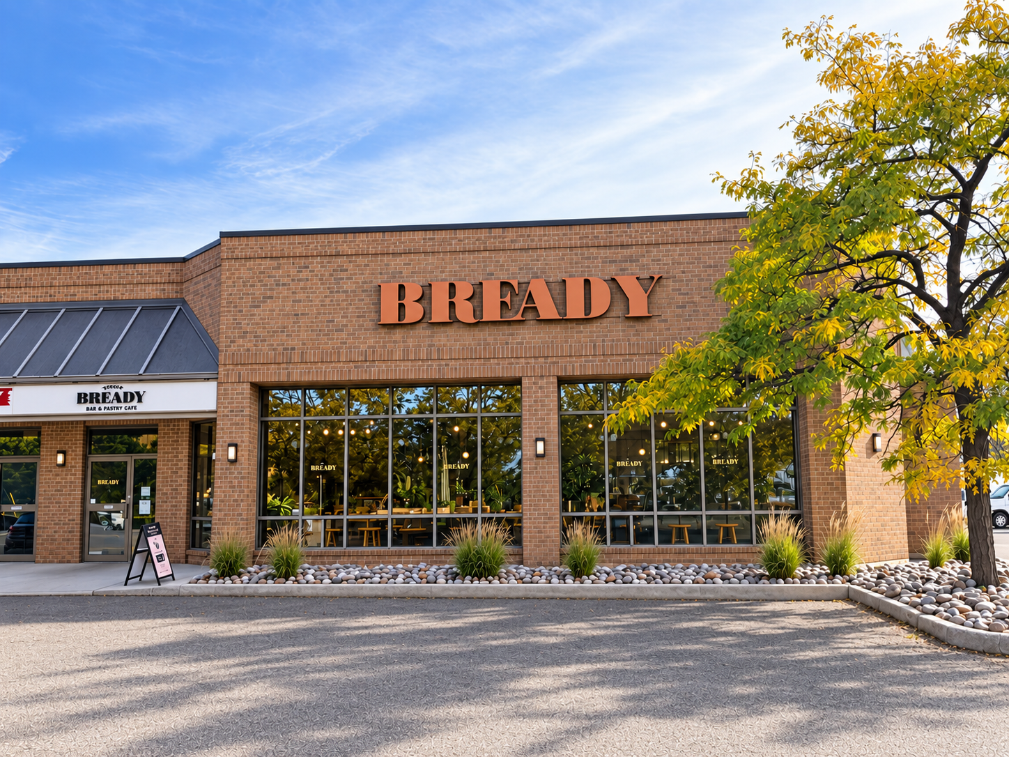 Bready Concord storefront — brick façade with terracotta BREADY lettering and a tree in fall colour