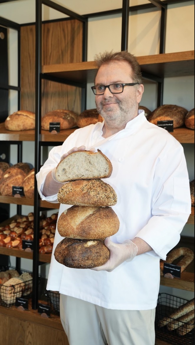 Our baker holding fresh Bready sourdoughs